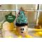 This is a whimsical Christmas elf made with a real dried gourd. This elf's name is Fraser. His face is carved into the round gourd shell. 